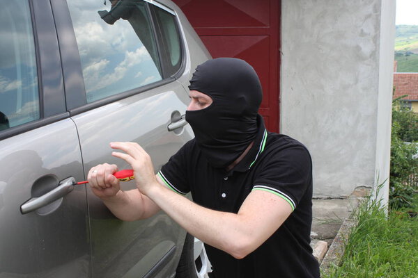 Автоугонщик пытается влезть в машину с отверткой
.