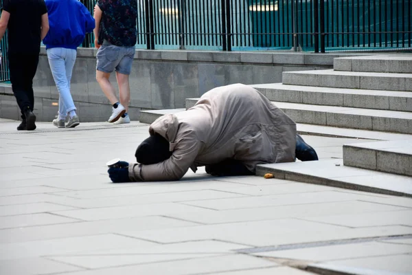 Unhappy homeless man asking help