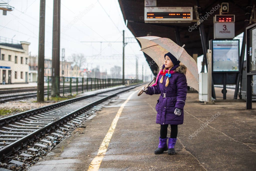 Little child waiting on a railway train station.