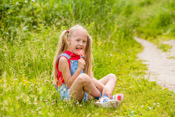 Блондинка с длинными волосами и конфетами на палочке