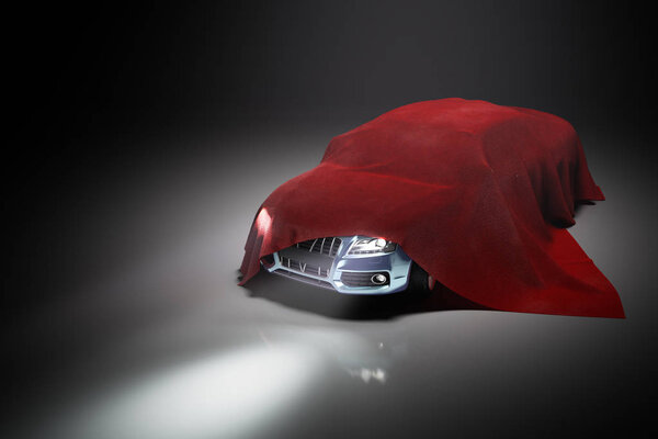 концепция презентации автомобиля под красной тканью в дарке
 