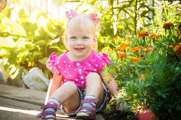 Vacker glad liten baby flicka på en grön ljusa sommar-bakgrund — Stockfoto
