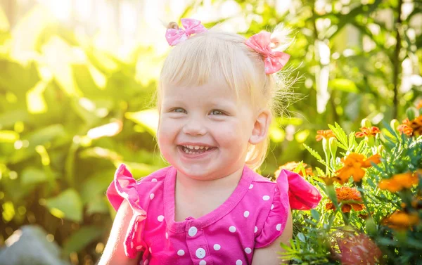 Vacker glad liten baby flicka på en grön ljusa sommar-bakgrund — Stockfoto