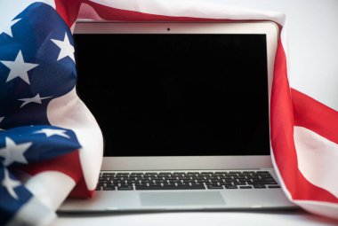 Beyaz arkaplanda kopyalama alanı olan ABD bayrağı ve dizüstü bilgisayarı
