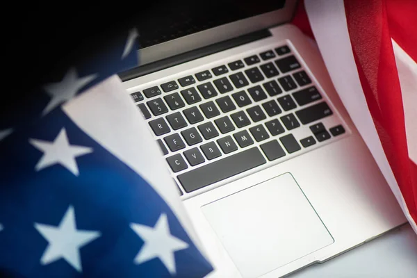 Bandiera e laptop degli Stati Uniti su sfondo bianco con spazio di copia Immagini Stock Royalty Free