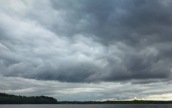 Dramático cielo nublado con nubes de trueno sobre el lago — Foto de Stock