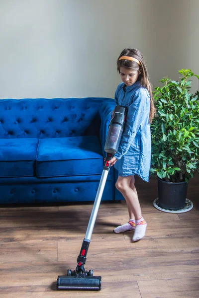 Ένα Κορίτσι Τζιν Φόρεμα Σκουπίζει Ένα Δωμάτιο Έναν Μπλε Καναπέ Εικόνα Αρχείου
