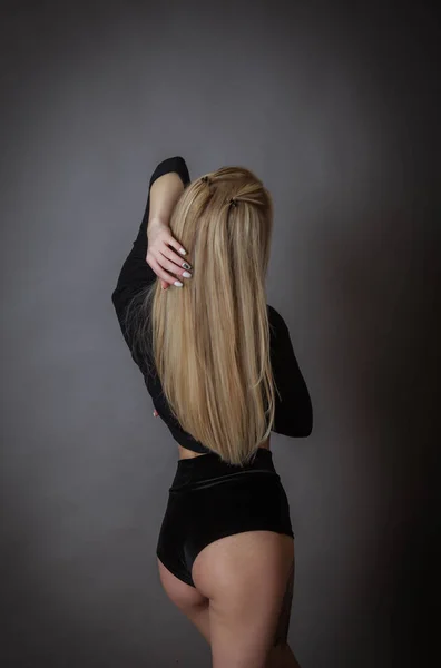 Blonde Beauty Poses Black Bodysuit Her Back Wall Showing Her — Stock Photo, Image