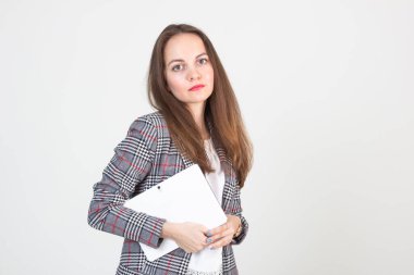 İş elbisesi içinde güzel gözleri ve elinde tableti olan genç bir kadının portresi.