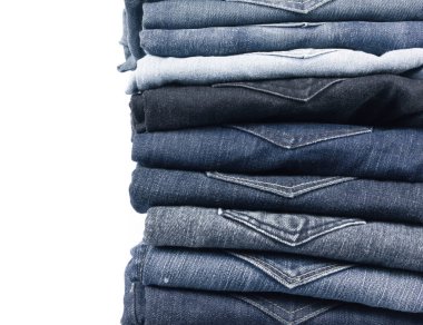 Tasarım ve metin girdisi için beyaz arkaplan üzerine istiflenmiş kot pantolon.