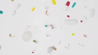 Animasyon yavaş çekim düşen haplar. Çok renkli kapsüller ve haplar: antibiyotikler, vitaminler, diyet takviyeleri. Eczaneden alınmış. İlaç şirketi, endüstri, 3 boyutlu animasyon.