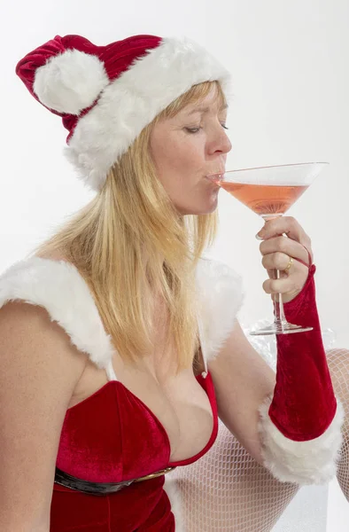 金发碧眼的女人穿着圣诞老人的化装舞会服装 拿着饮料 — 图库照片