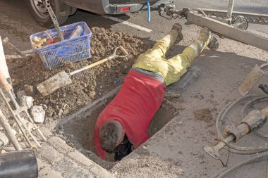 Yeni bir su sayacı yolun ortasında yükleme. İngiltere'de. Yeni siyah plastik metre konut işçisi yüzü aşağı yükler.