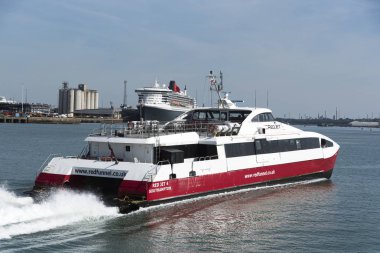 Southampton su, İngiltere'de İngiltere'de. Isle of Wight Queen Mary 2 ile devam için arka planda bir kırmızı huni fastferry.