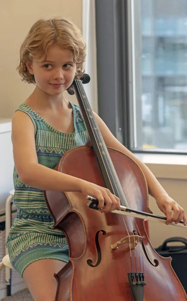 Young music student playing a cello