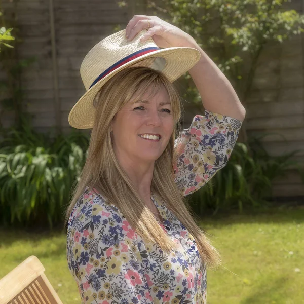 Woman Wearing Floral Summer Dress Putting Straw Hat — Stock Photo, Image