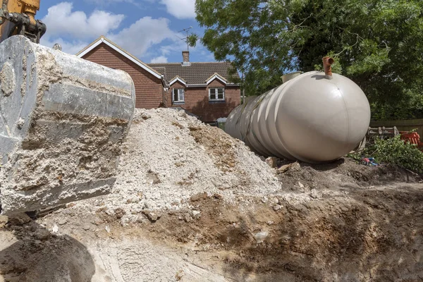 在英国英国汉普郡的一个住房开发项目上 一名切割机爬虫为一辆地下坦克挖掘战壕 — 图库照片