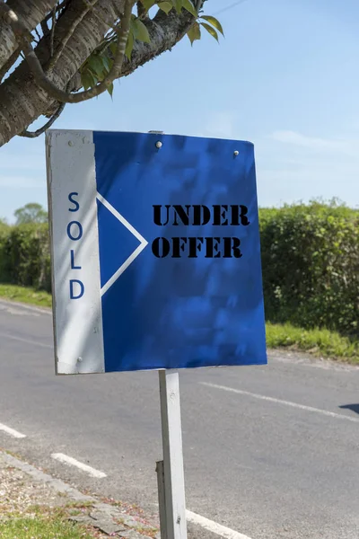Property under offer and sold sign on a self standing board.