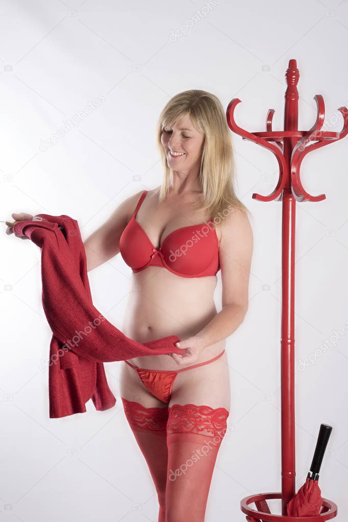 Blond woman in red underwear holding a jacket