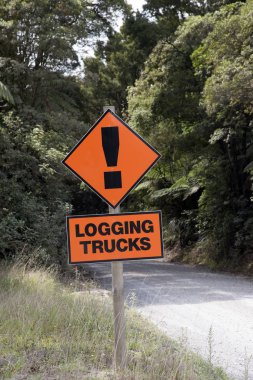 Logging trucks warning sign on a dirt road in Manginangina New Zealand clipart