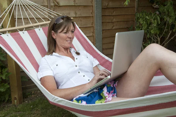 Vrouw Met Behulp Van Een Laptopcomputer Uit Haar Tuin Hangmat — Stockfoto