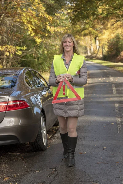 Vrouwelijke Automobilist Het Blussen Van Een Reflecterende Veiligheid Driehoek Een — Stockfoto