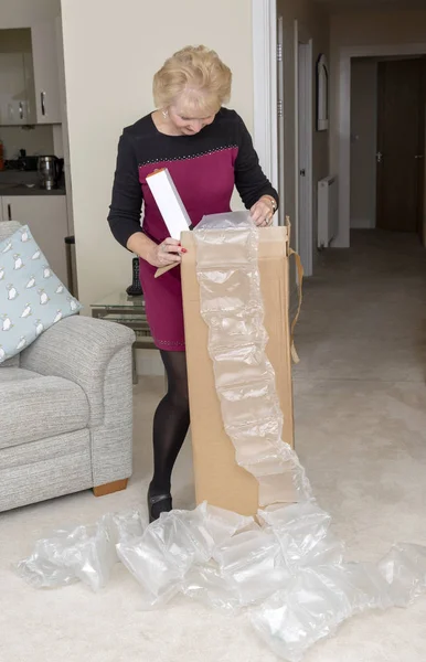 Kobieta Otwierając Pudełko Nadmiernej Ilości Ochronne Tworzywa Sztucznego Pakowania Materiałów — Zdjęcie stockowe