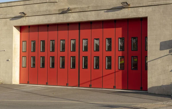 A Community fire station with red sliding doors