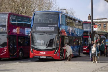 Salisbury, Wiltshire, Ingiltere. Mart 2019, Salisbury şehir merkezindeki Blue Boar Row 'daki otobüsler. Çift katlı otobüs yatılı yürüyüş çerçevesi ile yaşlı bir bayan