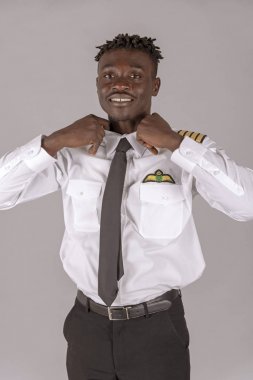 Afrikalı bir çocuk saç modeli ile genç bir havayolu pilotu. Mürettebat üyesi üniforma siyah kravat ve yaka kontrol