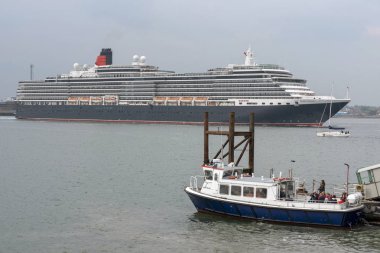 Southampton Water, İngiltere, İngiltere. Mayıs 2019. Queen Victoria yolcu gemisi devam ediyor ve Southampton Water Hythe Pier feribot, güney İngiltere