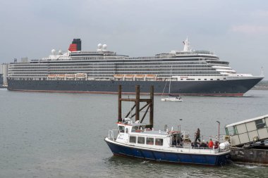 Southampton Water, İngiltere, İngiltere. Mayıs 2019. Queen Victoria yolcu gemisi devam ediyor ve Southampton Water Hythe Pier feribot, güney İngiltere