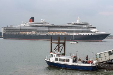 Southampton Water, İngiltere, İngiltere. Mayıs 2019. Queen Victoria yolcu gemisi devam ediyor ve Southampton Water Hythe Pier feribot, güney İngiltere