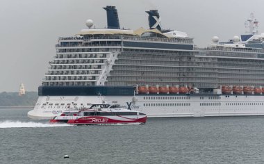Southampton, İngiltere, İngiltere. Mayıs 2019. Yolcu gemisi Celebrity Siluet devam ediyor ve Southhampton Su üzerinde giden. Bir Redjet 7 feribot onu kıç geçen.