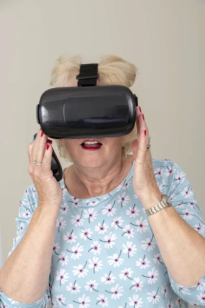 Portsmouth UK, May 2019. Elderly woman having fun wearing virtual reality goggles