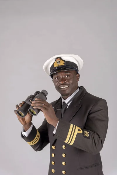 England, UK. May 2019. A naval officer in uniform holding a pair of binoculars