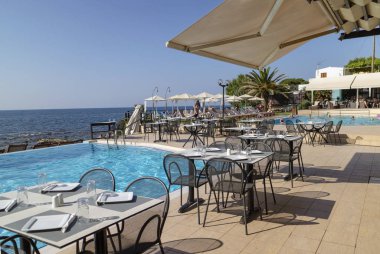 Girit, Yunanistan. Haziran 2019. Poolside masa ve sandalyeleri Hanya Körfezi 'nin Kuzey Girit 'e bakmaktadır..