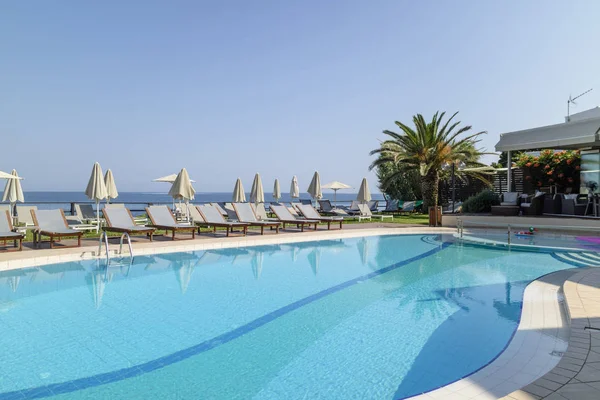 Girit, Yunanistan. Haziran 2019. Havuz kenarındaki şezlong, Hanya Körfezi Kuzey Girit 'te bir yüzme havuzuna bakmaktadır..