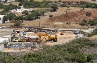 Plaka, Girit, Yunanistan. Haziran 2019. Plaka kıyı köyü nün arkasında inşaat çalışmaları yürütülmektedir. Yeni evler ve daireler inşa etmek.