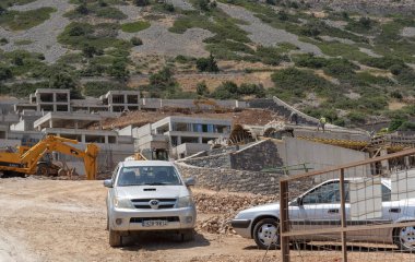 Plaka, Girit, Yunanistan. Haziran 2019. Plaka kıyı köyü nün arkasında inşaat çalışmaları yürütülmektedir. Yeni evler ve daireler inşa etmek.