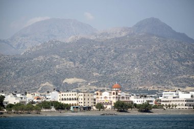 Ierapetra, Girit, Yunanistan. Haziran 2019. Ierapetra güney kıyı kasabası ve bir dağ arka plan ile Agia Fotini kilisesi
