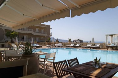 Girit, Yunanistan. Haziran 2019. Girit,Yunanistan'da bir otelin yüzme havuzu çevresinde yeme ve güneşlenme alanı.