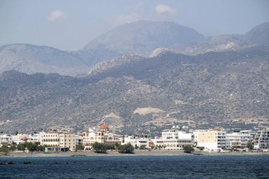 Ierapetra, Girit, Yunanistan. Haziran 2019. Ierapetra güney kıyı kasabası ve bir dağ arka plan ile Agia Fotini kilisesi