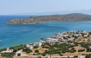 Plaka, Girit, Yunanistan. Haziran 2019. Plaka sahil beldesi ve Spinalonga Adası'ndaki eski Cüzzam Kolonisi'ne genel bir bakış.