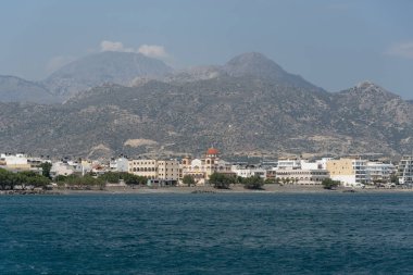 Girit, Yunanistan. Haziran 2019. Güney Girit ve Agia Fotini Kilisesi ve rıhtıma yakın dağlar ile Ierapetra kasabası