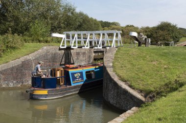 Devizes, Wiltshire, İngiltere, İngiltere. Ağustos 2019. Dar tekne Kennet ve Avon Kanalı üzerinde kilitlerin Caen Hill uçuş bir kilit girerek.