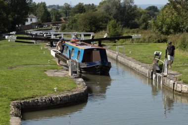 Devizes, Wiltshire, İngiltere, İngiltere. Ağustos 2019. Dar tekne Kennet ve Avon Kanalı üzerinde kilitlerin Caen Hill uçuş bir kilit bırakarak.