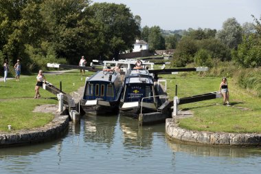 Devizes, Wiltshire, İngiltere, İngiltere. Ağustos 2019. İki dar tekne, Caen Hill'in kilitlerinin kilitlerinden birinin arasından birlikte geçiyor..