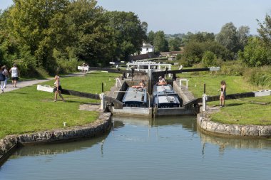 Devizes, Wiltshire, İngiltere, İngiltere. Ağustos 2019. İki dar tekne, Caen Hill'in kilitlerin üzerindeki kilitlerden birinden birlikte geçiyor. Kilitte su seviyesinin yükselmesini beklemek.