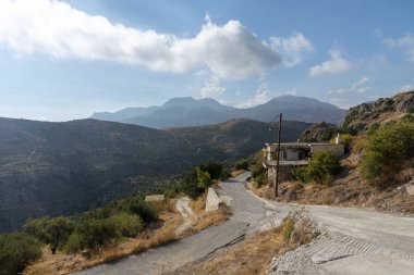 Agios Stefanos, Girit, Yunanistan. Eylül 2019. Girit 'in en eski köylerinden biri olan Agios Stefanos' un dağ yamacındaki Girit evinden geçen kırsal manzaralı bir yol. 